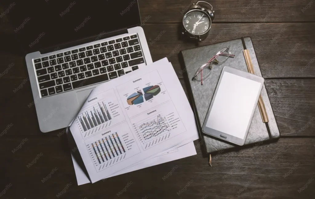Pracovní stůl s finančním reportem a notebookem